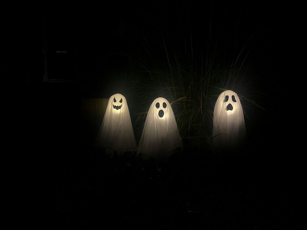  Three illuminated ghosts in a dark surrounding creating a spooky feeling.