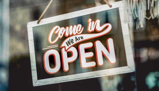  A hanging door sign saying ‘Come in we are open’