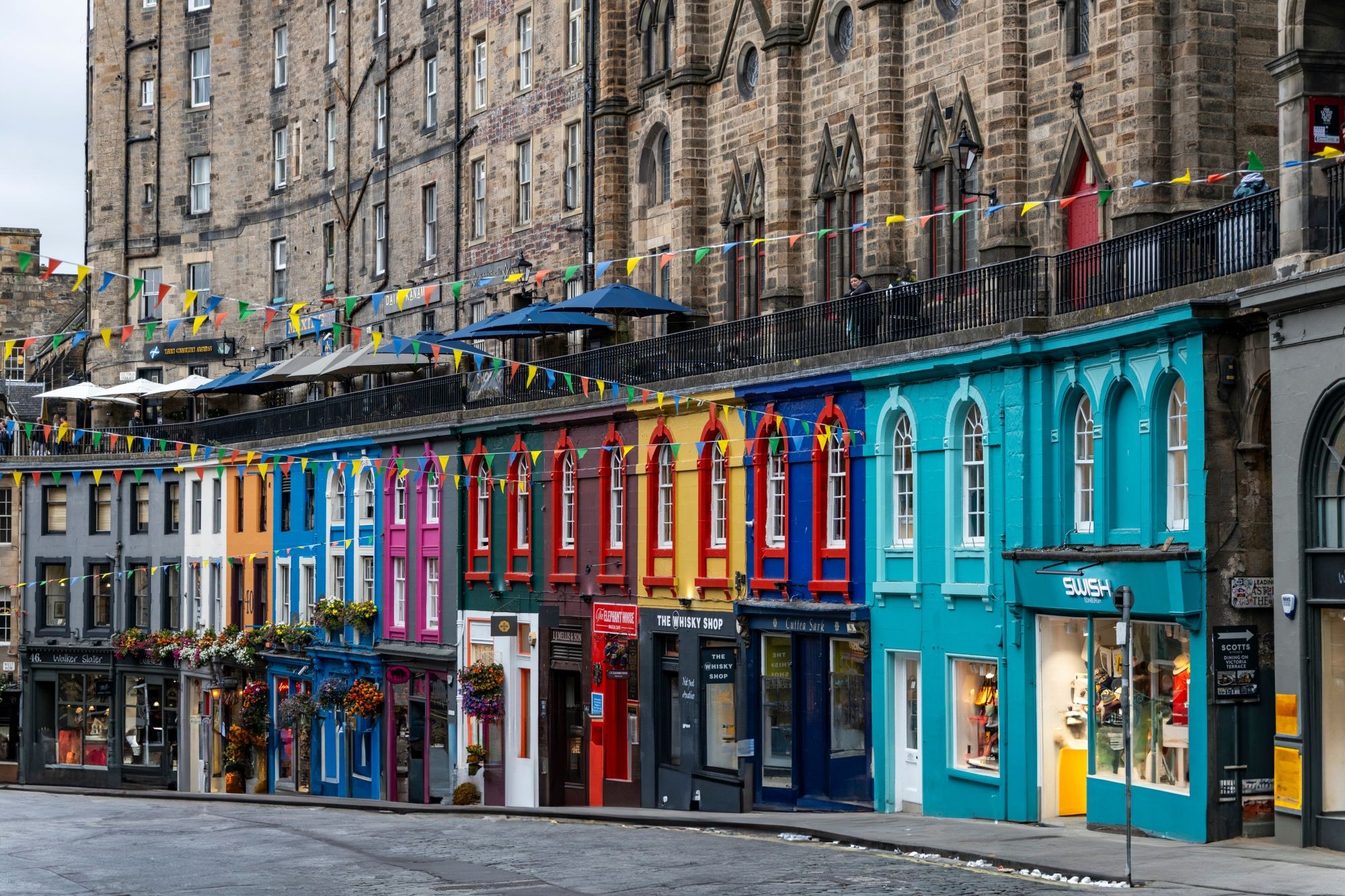 A row of colourful shops along a street in Edinburgh.