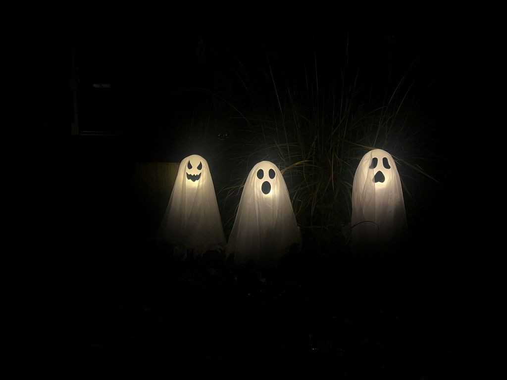  Three illuminated ghosts in a dark surrounding creating a spooky feeling.