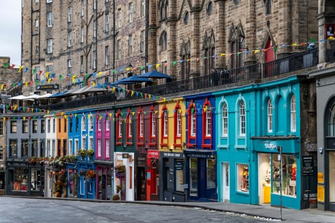 A row of colourful shops along a street in Edinburgh.