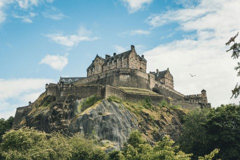 Edinburgh Castle perched on Castle Rock surrounded by greenery