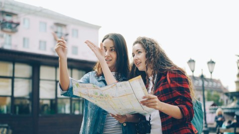 Two women reading a map, deciding on a direction