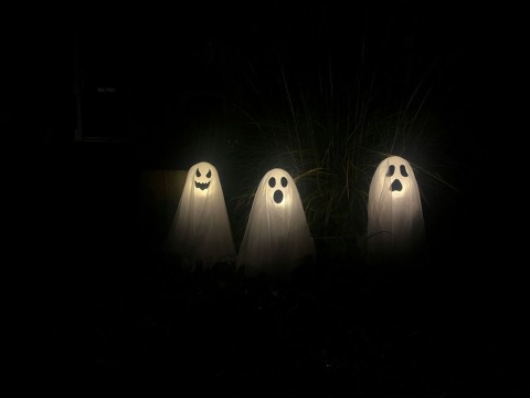  Three illuminated ghosts in a dark surrounding creating a spooky feeling.