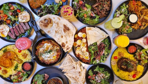 Top-down view of a vibrant Middle Eastern food spread on a table.