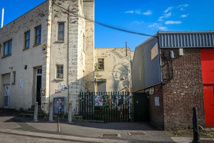 Street art in Bristol on a white building in an industrial area.