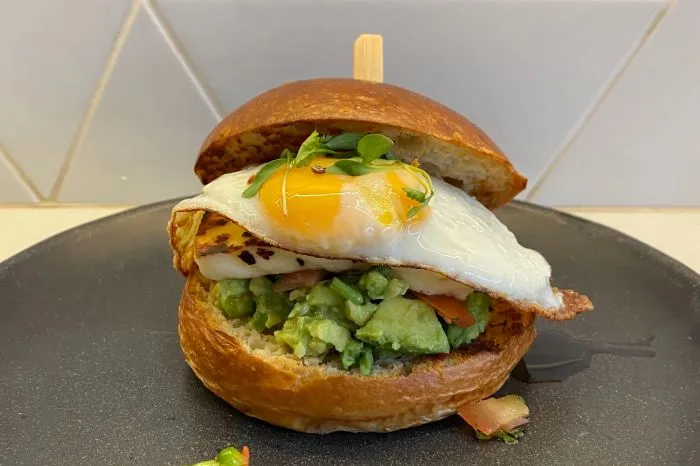 Cowan & Sons veggie big brunch bun with egg, avocado, halloumi, and other fillings.