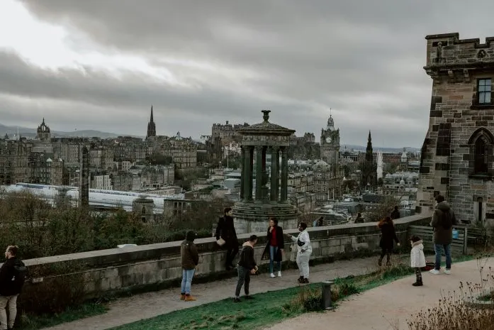 A group of people admiring the view of Edinburgh from Calton Hill.