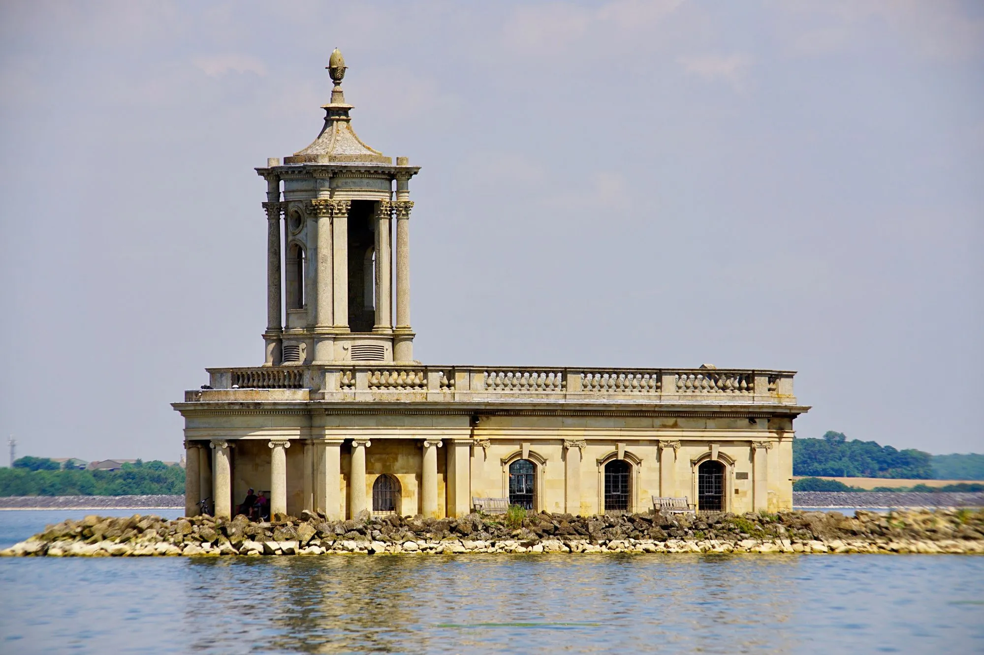 Normanton Church sitting on a rocky embankment surrounded by Rutland Water.